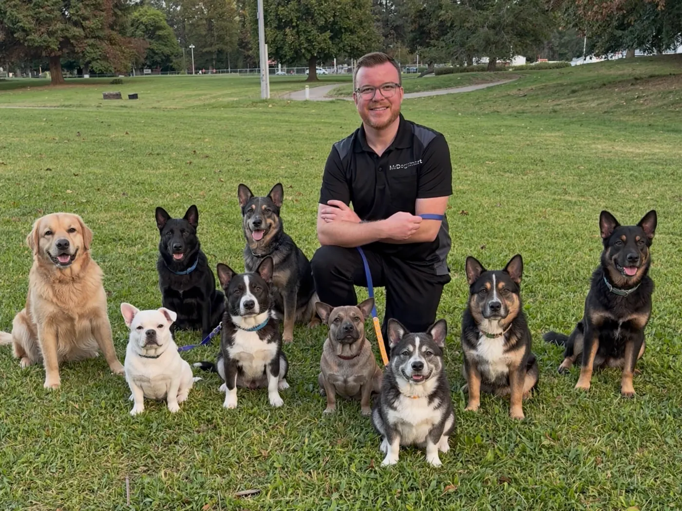 Jonathan Drouin accroupi dans un parc, entouré de dix chiens assis